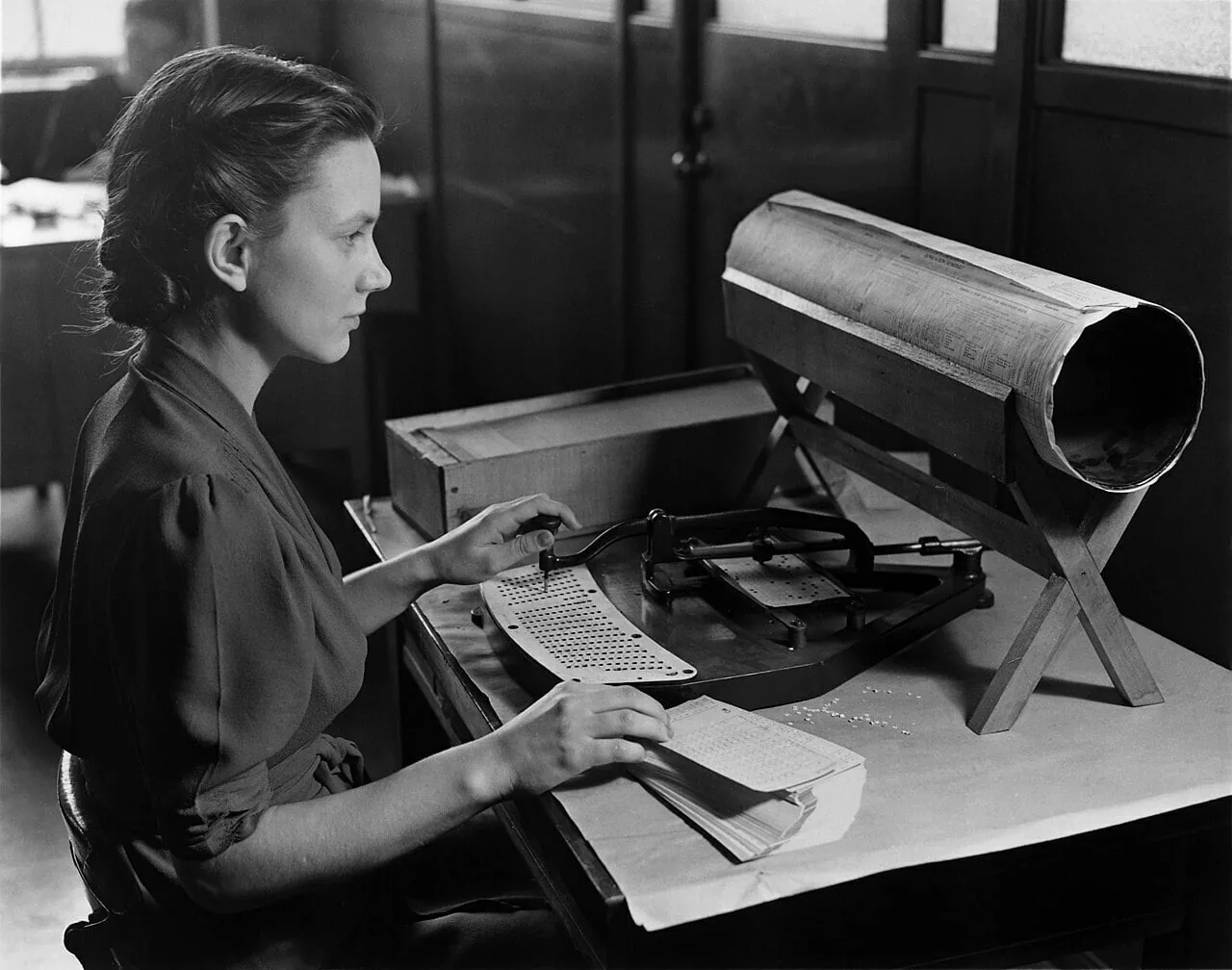 A punch-card operator keys in data by hand, one record at a time.